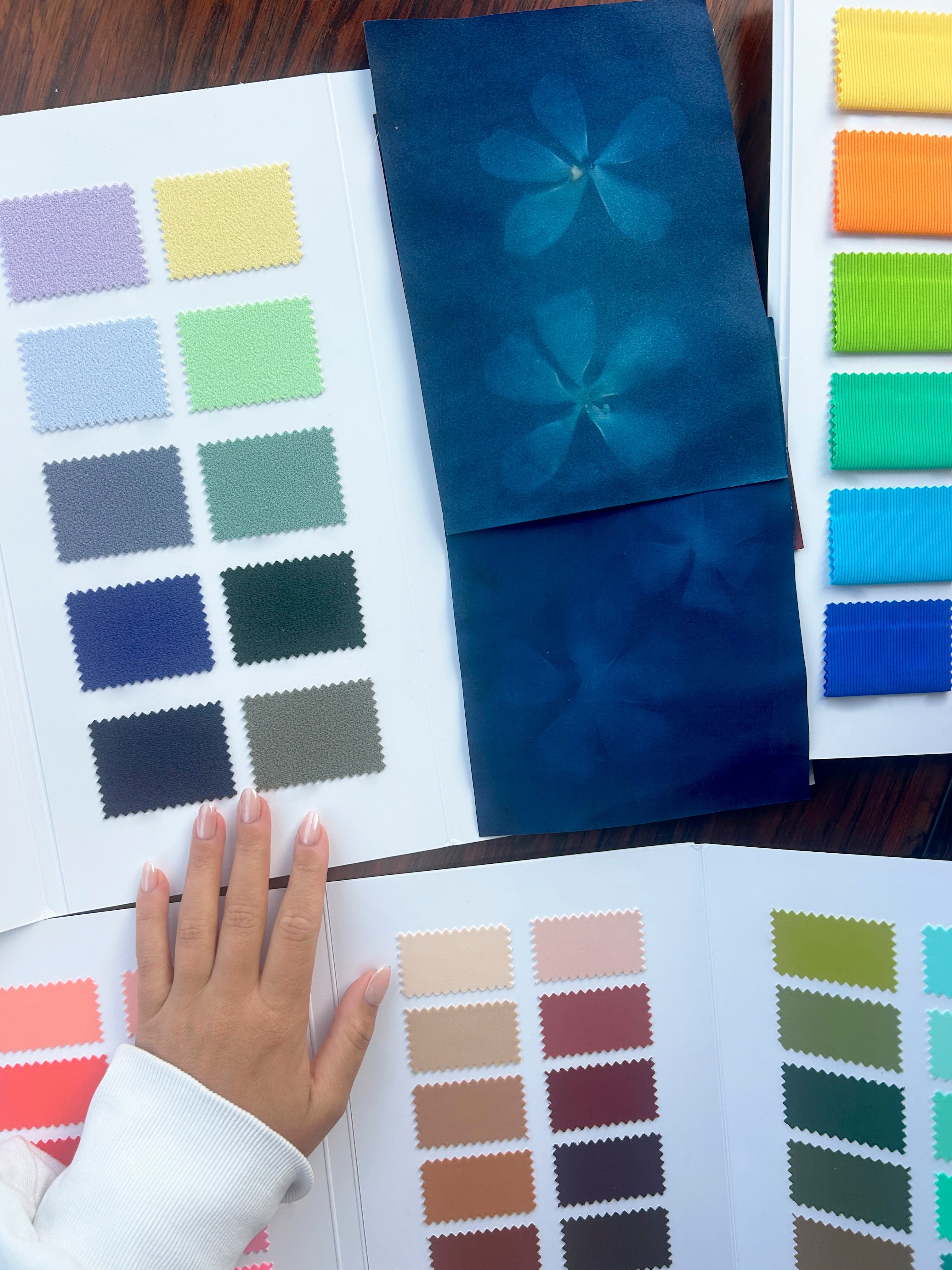 Color swatch book with a hand pointing to a blue color sample