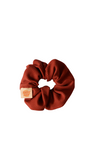 Brown hair scrunchie with a brand tag on a white background