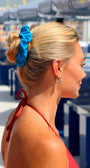 Woman with a blue scrunchie in her hair at an outdoor event