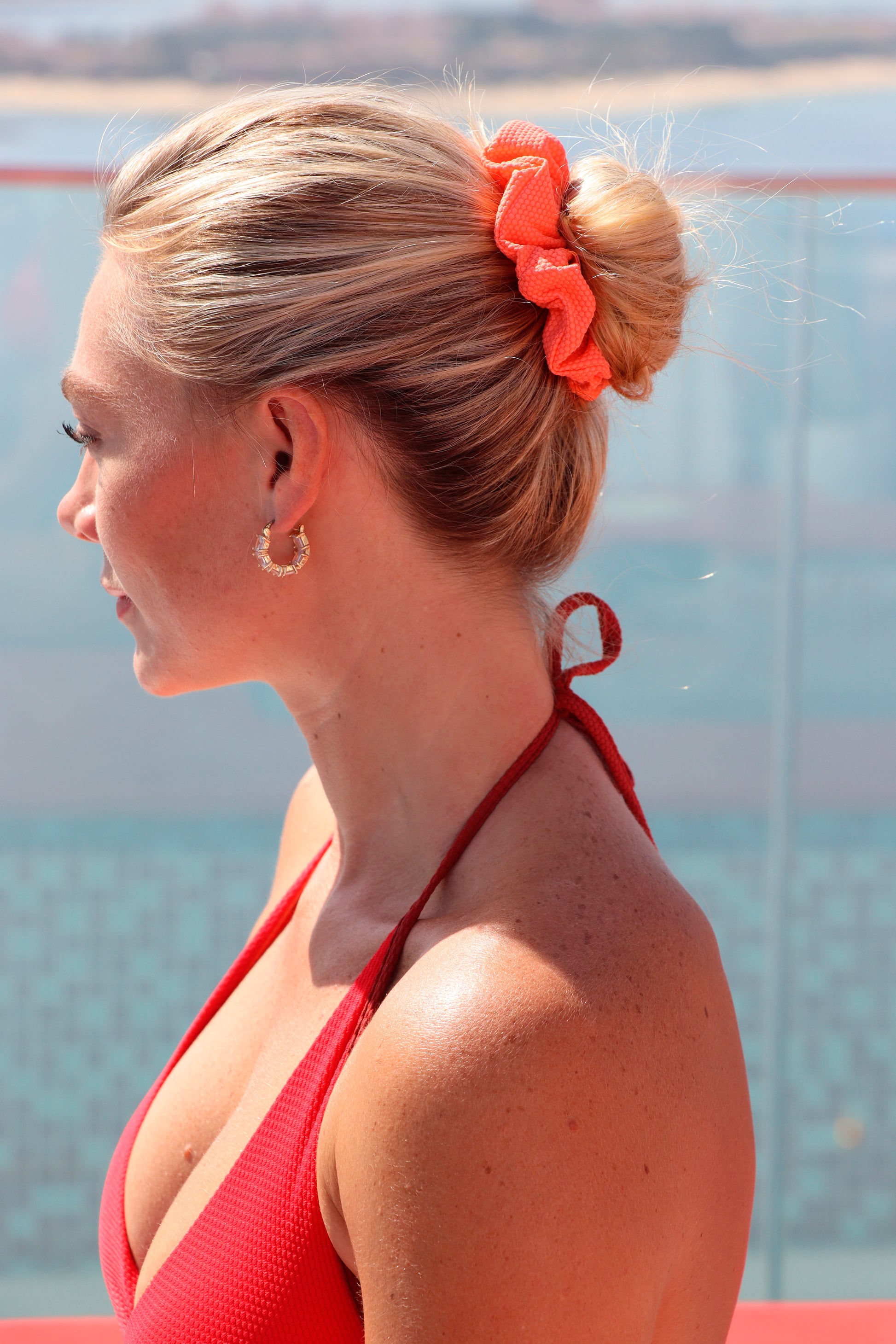 Woman with a bun wearing an orange scrunchie